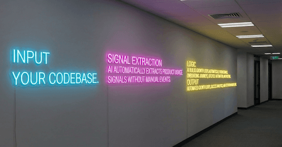 Office hallway with neon signs displaying: INPUT YOUR CODEBASE, SIGNAL EXTRACTION - Skene Agent automatically extracts product usage signals without manual events, LOGIC - Context layer for your AI to build growth loops automatically from signals. Onboarding journeys, lifecycle automation, and routing, OUTPUT - Automated growth loops, success analytics, and retention workflows