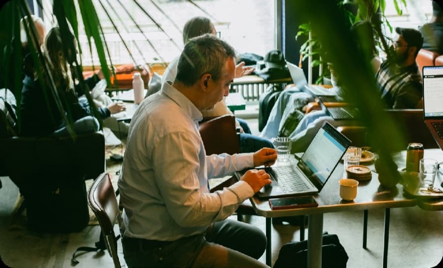 Participants working together on laptops at the Helsinki community gathering